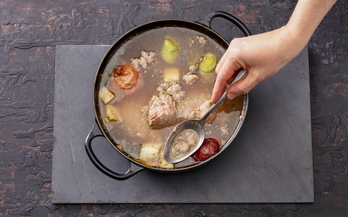 Löffel in Pfanne mit Flüssigkeit