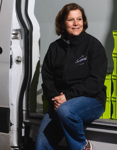 Sitzende Frau an einer Schiebetür von einem Auto 